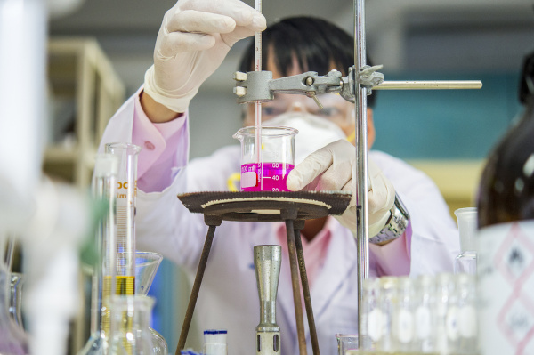 Químico manipulando vidrarias de laboratório, uma alusão à Físico-Química.