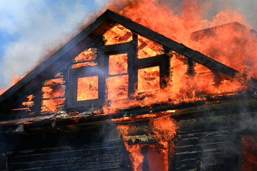 Casas pegando fogo, com chamas amarelas, um indicativo de combustão incompleta.