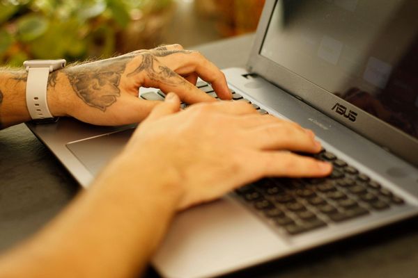 Pessoa utilizando notebook e ferramentas de IA para revisar e aprimorar a escrita. [imagem_principal]